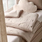 Soft taupe baby quilt with stitched pattern and rounded corner detailing