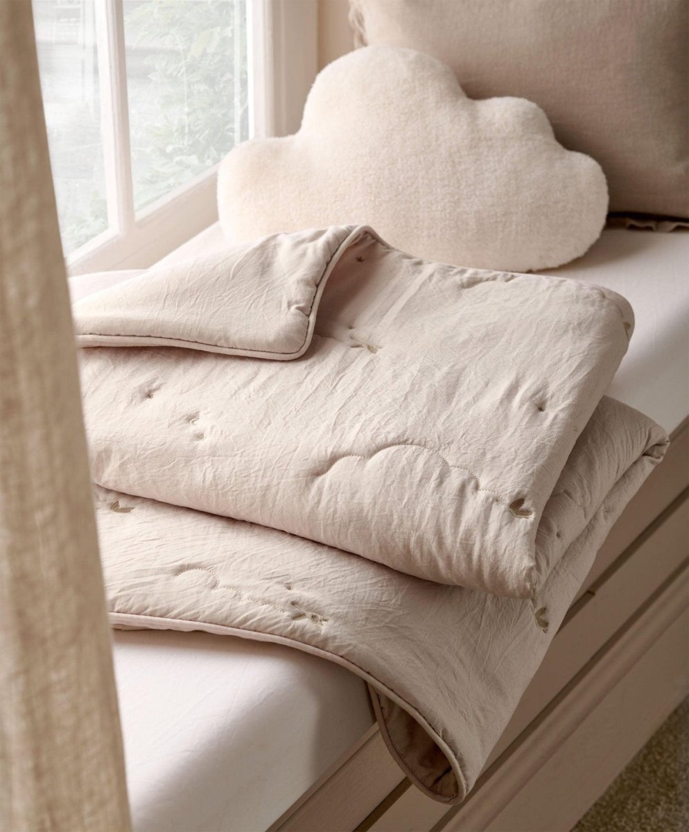 Soft taupe baby quilt with stitched pattern and rounded corner detailing