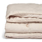 Soft taupe baby quilt folded stack with stitched border and small motif details