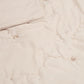 Soft taupe baby quilt with subtle stitched motifs and quilted texture