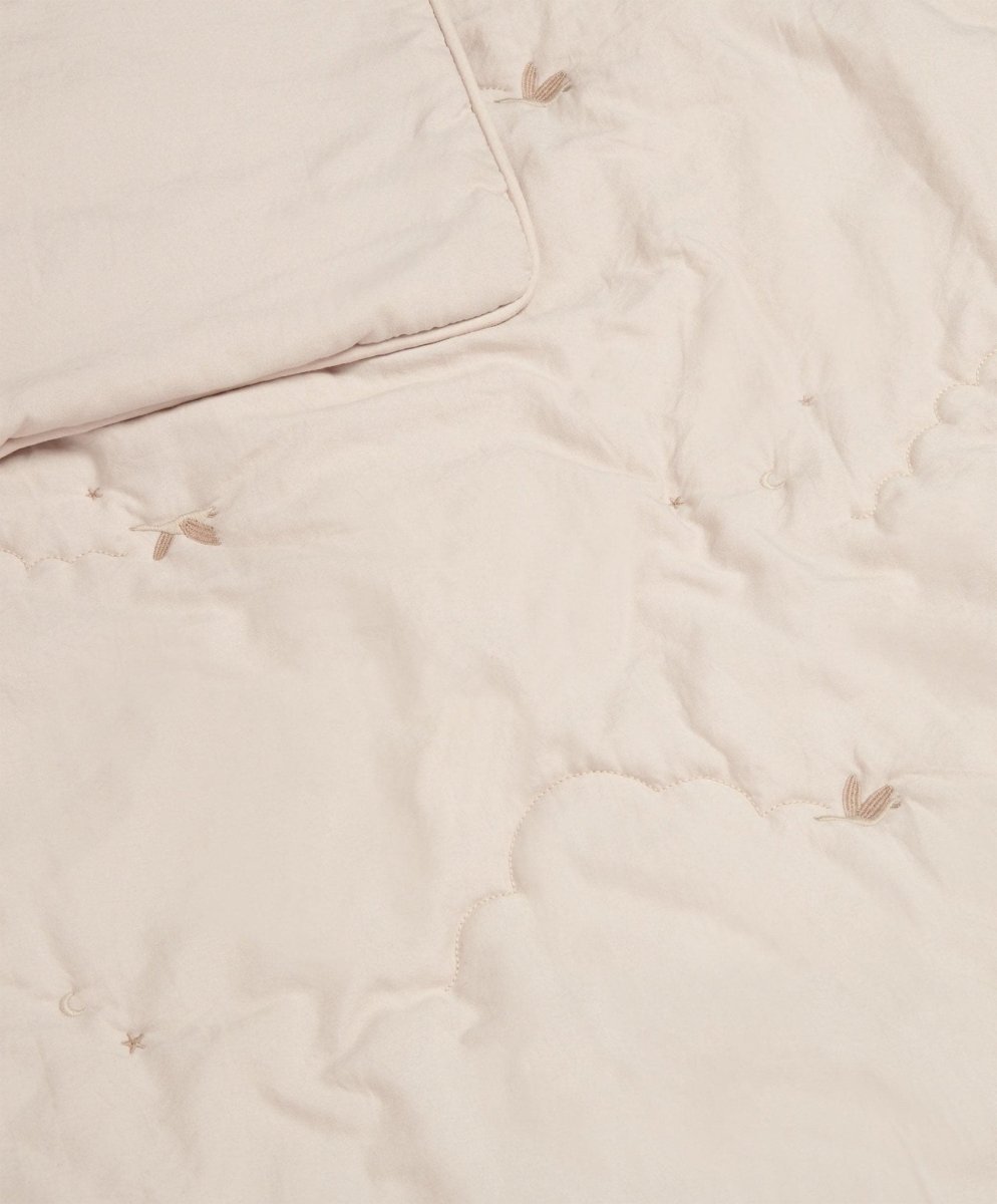 Soft taupe baby quilt with subtle stitched motifs and quilted texture