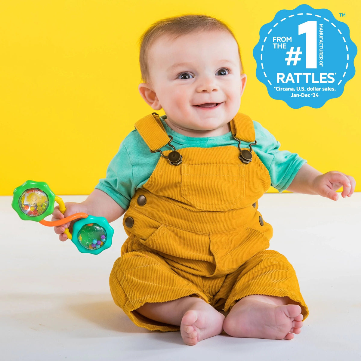 Barbell rattle toy in baby’s hands, turquoise and green end discs with bead-filled center