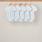 Set of 5 white ribbed short-sleeve bodysuits with snap crotch, hanging