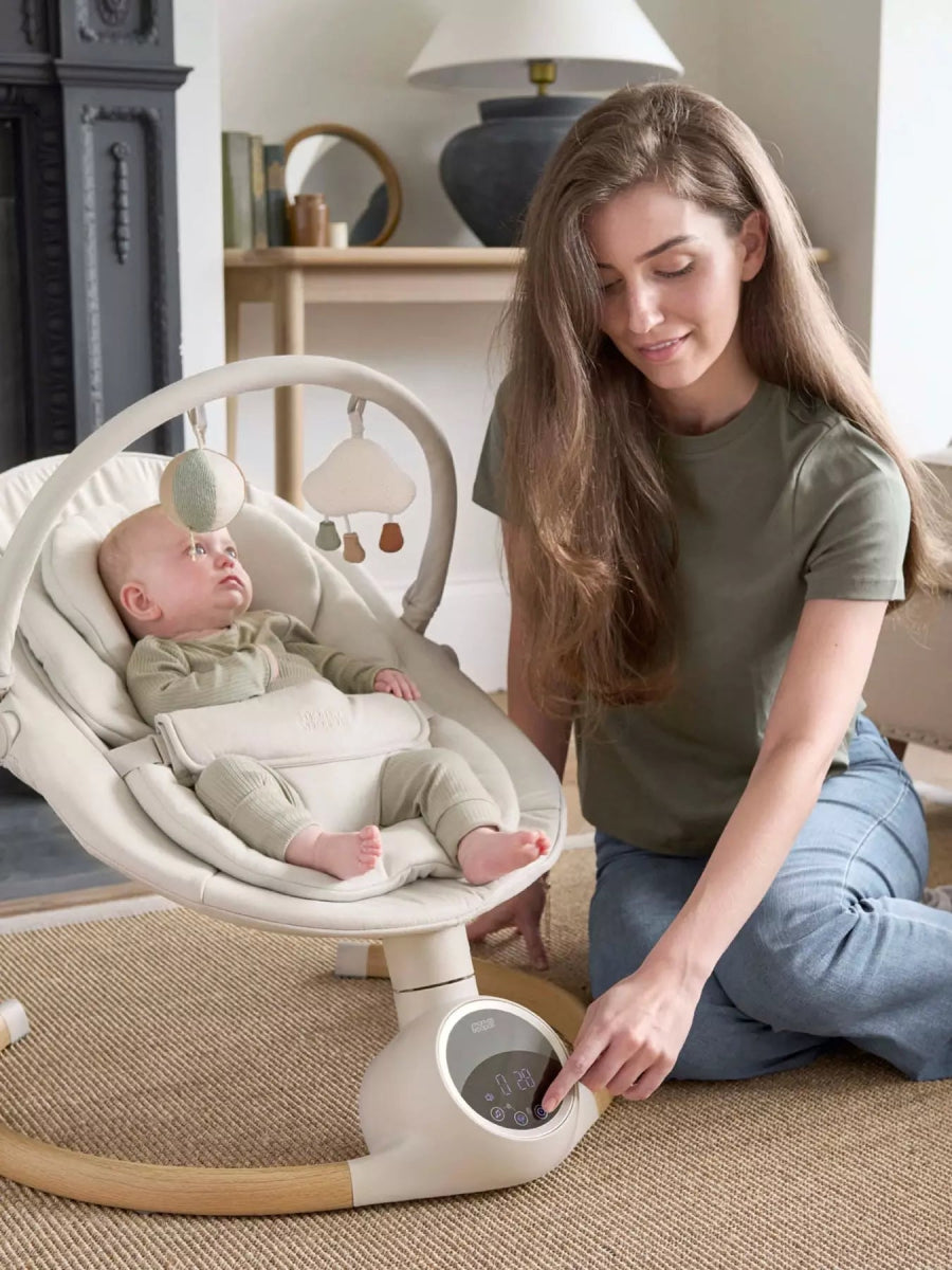 2-in-1 baby swing rocker in gray with white frame, baby lying and caregiver adjusting