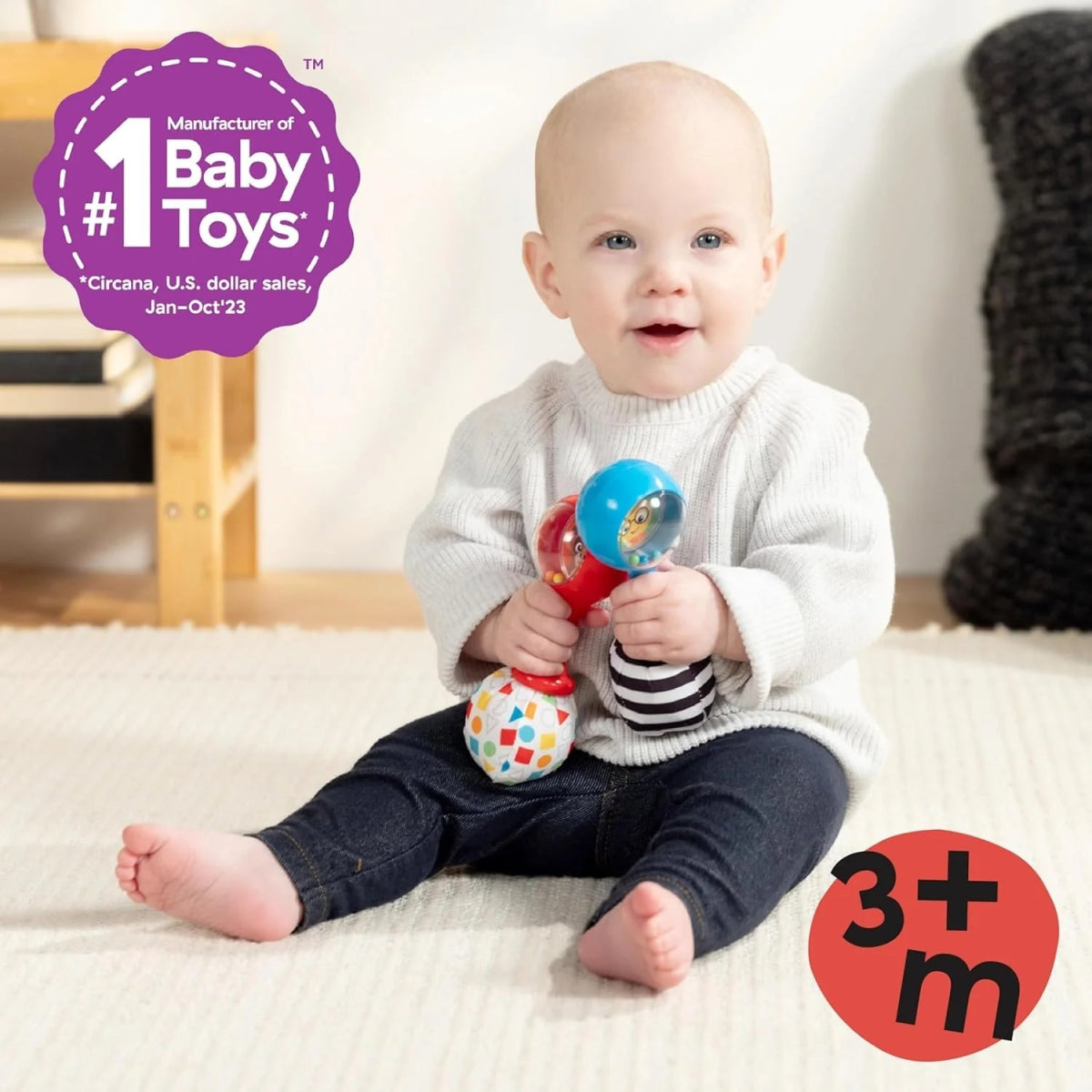 Baby holding shake-and-groove maraca rattles, blue and red toy in hands