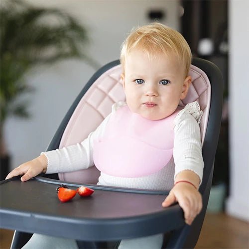 Ultrathin silicone bib, light pink, on a seated baby