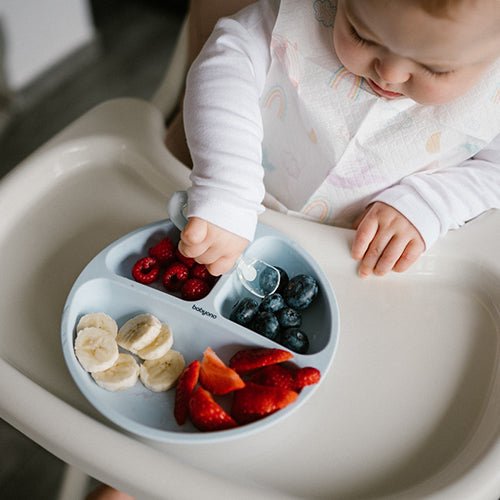 Light blue silicone suction plate with three sections holding fruit snacks