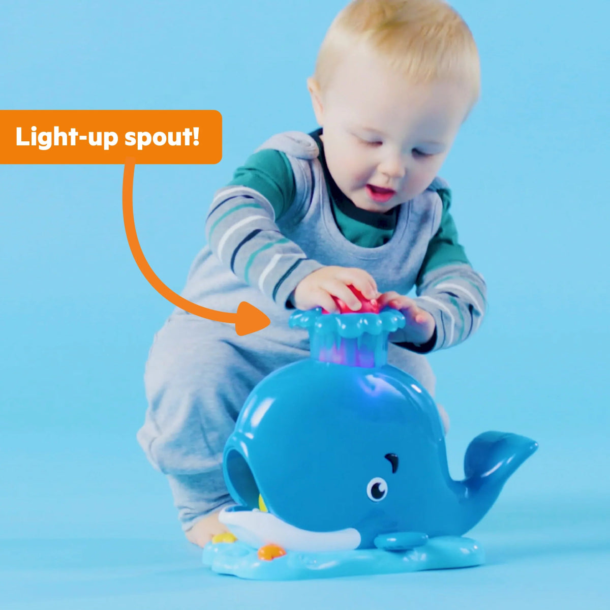 Baby activity ball popper toy with blue whale head and open spout, light-up feature