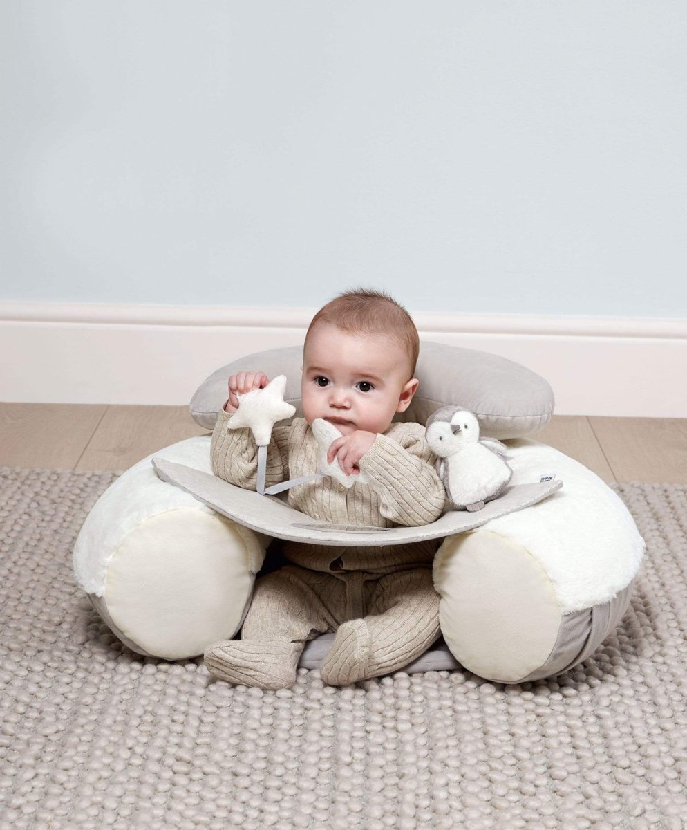 Plush baby floor seat with front play tray, baby sitting in a light gray cushion
