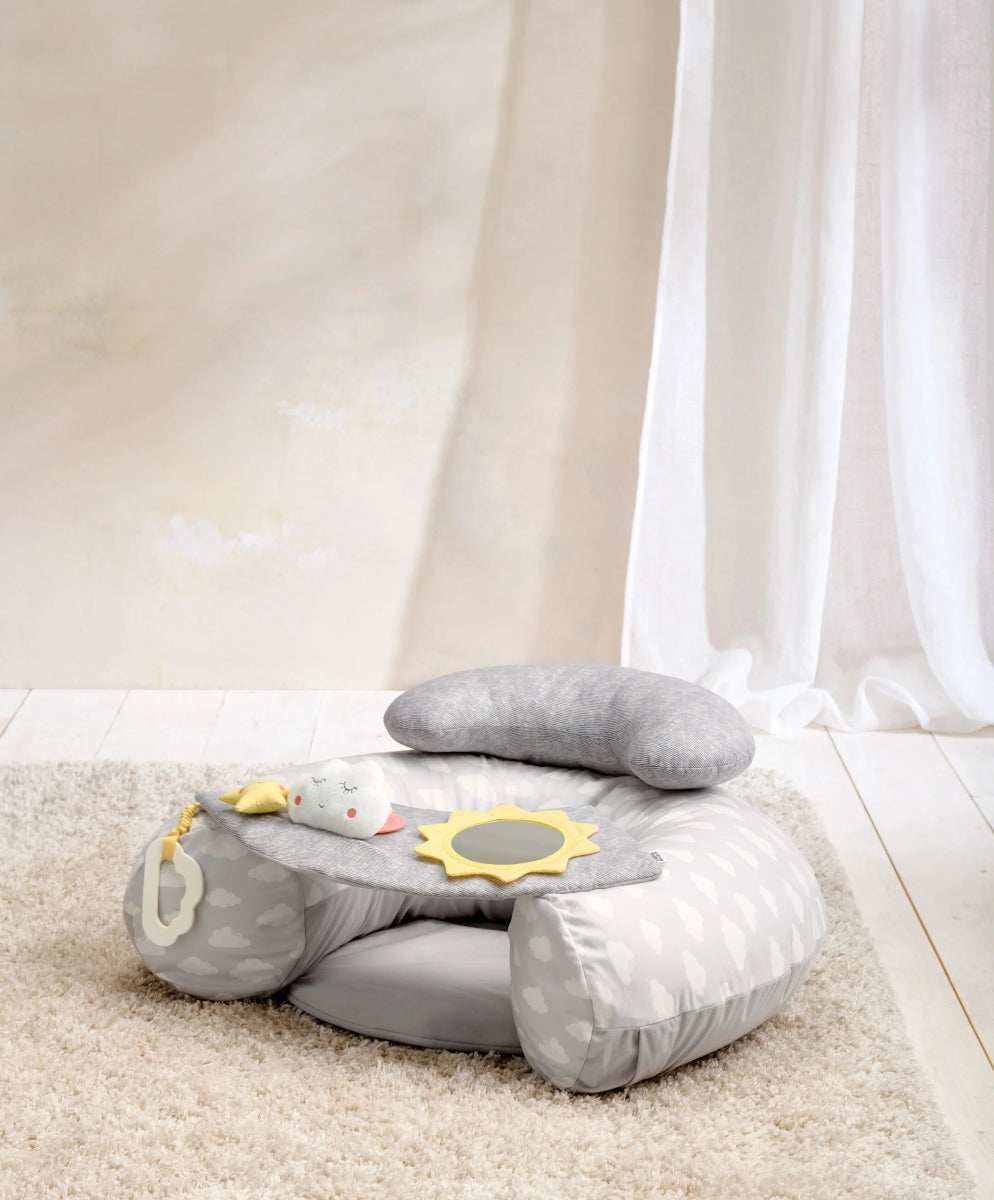 Gray and white infant play seat with cloud and star plush toys on cushion