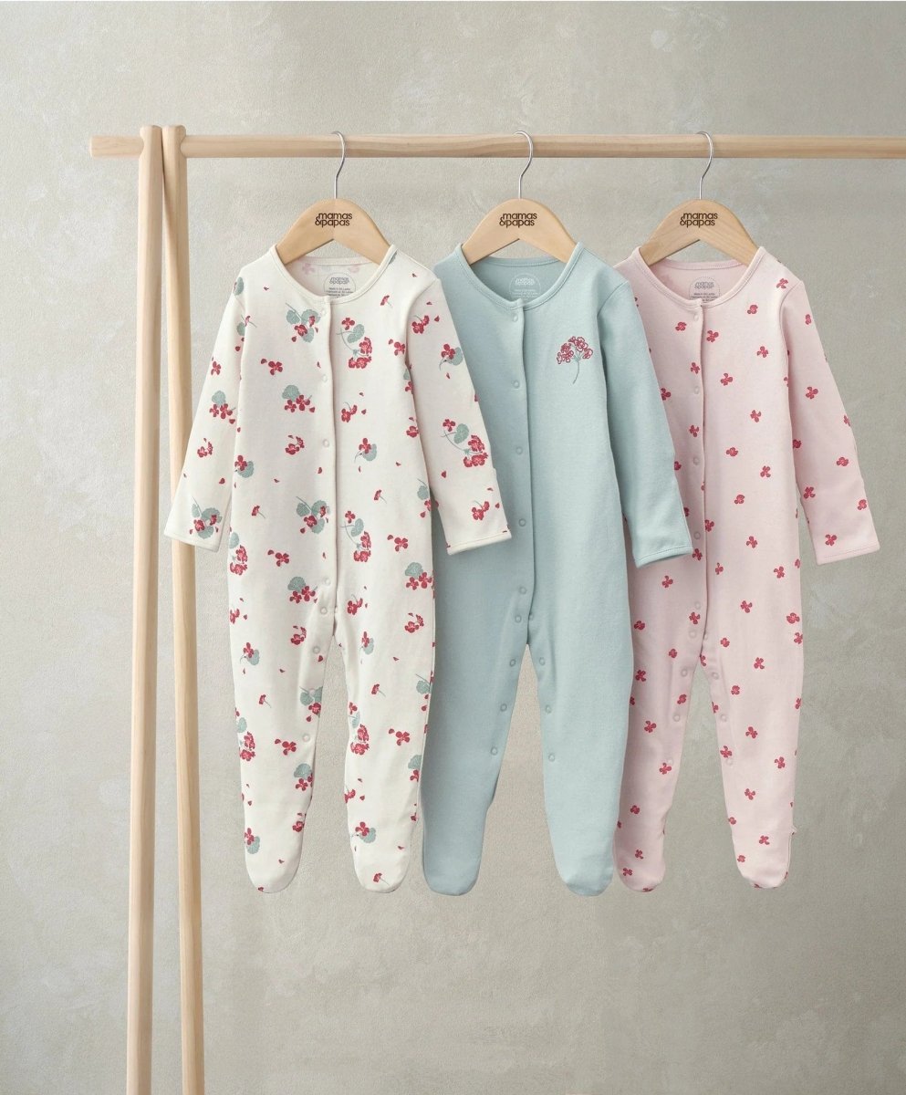Newborn sleepsuit set of 3: pink floral print footed long-sleeve onesie.
