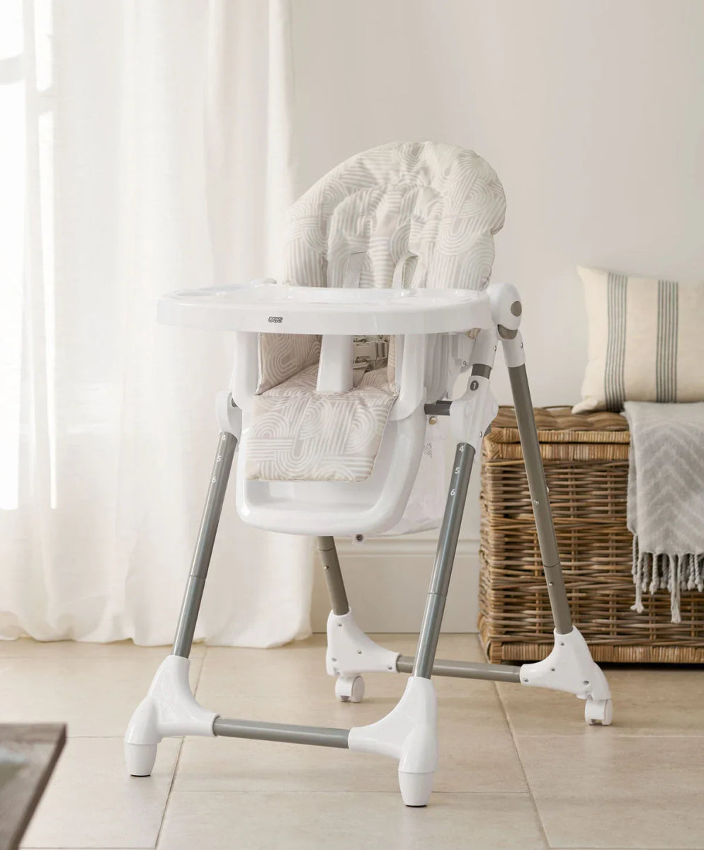 Baby high chair with white frame and textured light-pattern seat back