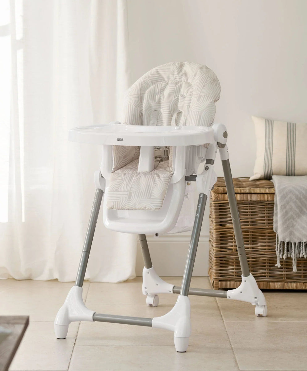 Baby high chair with white frame and light-patterned seat back and cushion