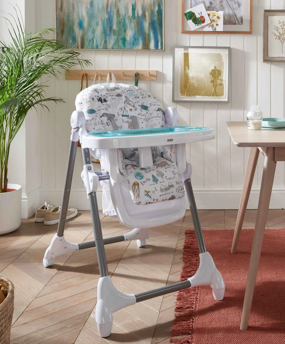 Baby high chair with white tray and animal-print seat in a home setting