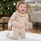 Light beige snowflake knit jumper with ruffled high neck on smiling child