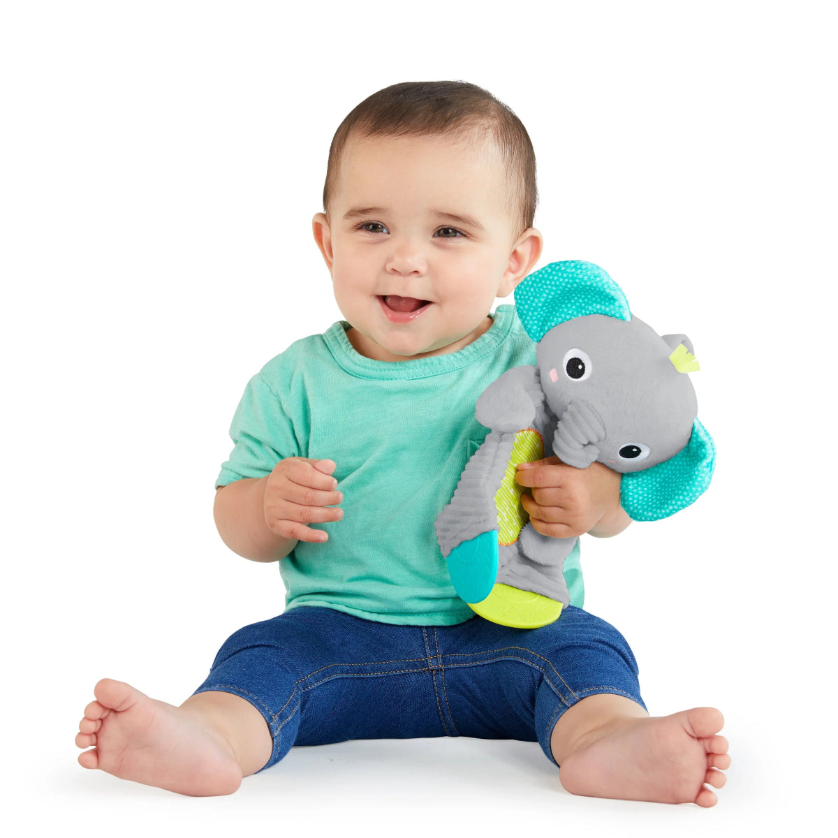 Plush elephant teether toy with teal ears and gray body, held by a smiling baby.