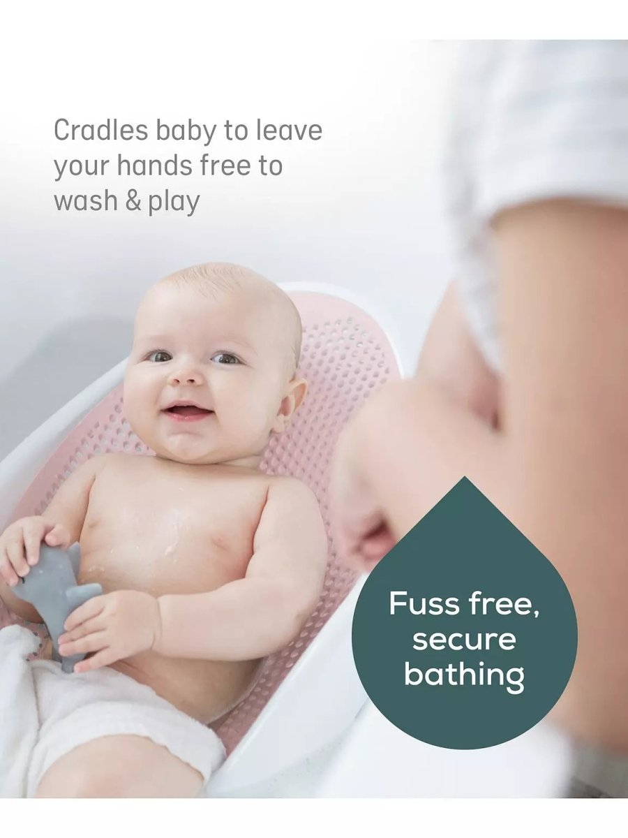 Pink baby bath support with soft-touch perforated insert and curved cradle for newborns