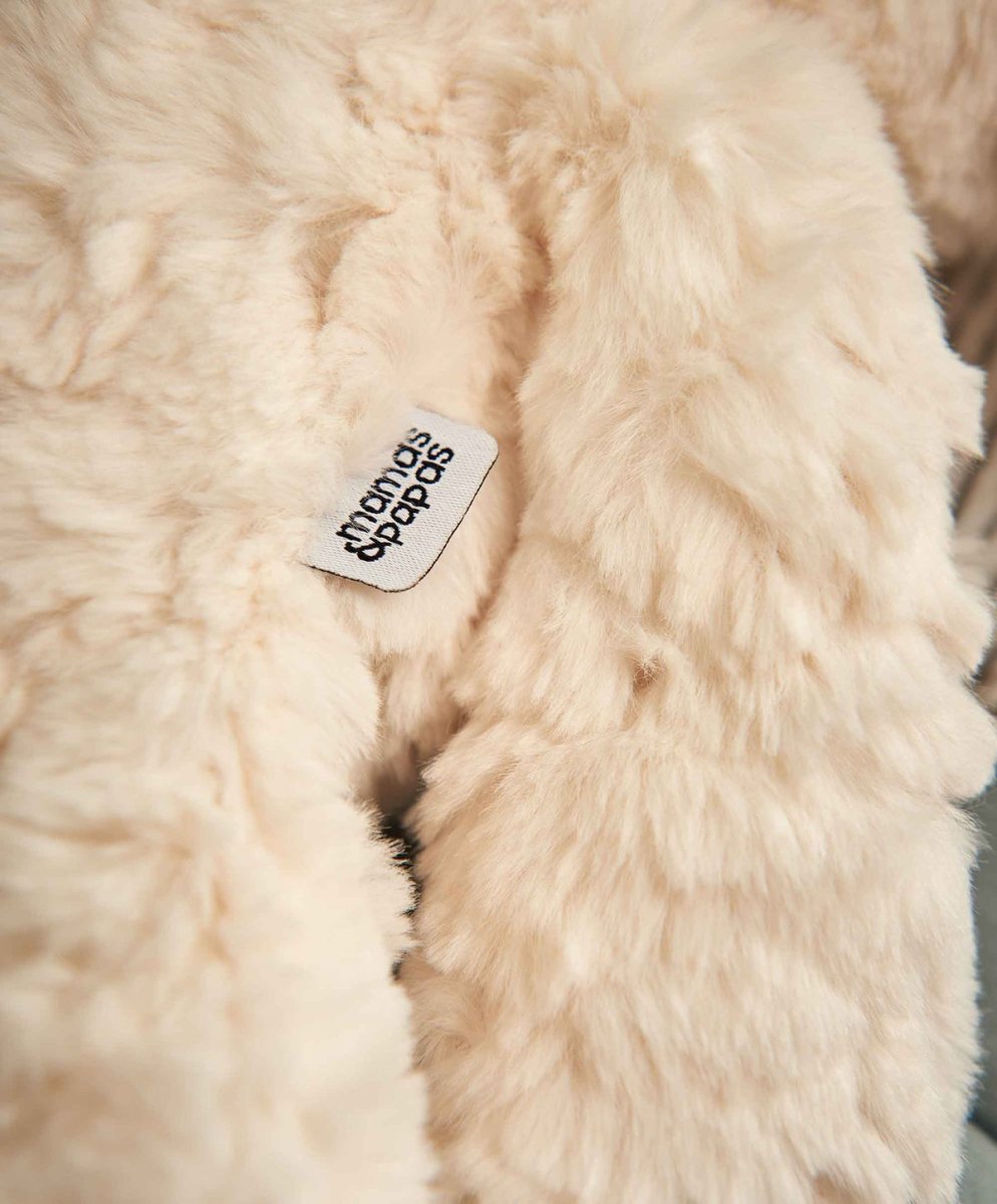 Cream plush lamb with fabric texture and fabric brand tag on side
