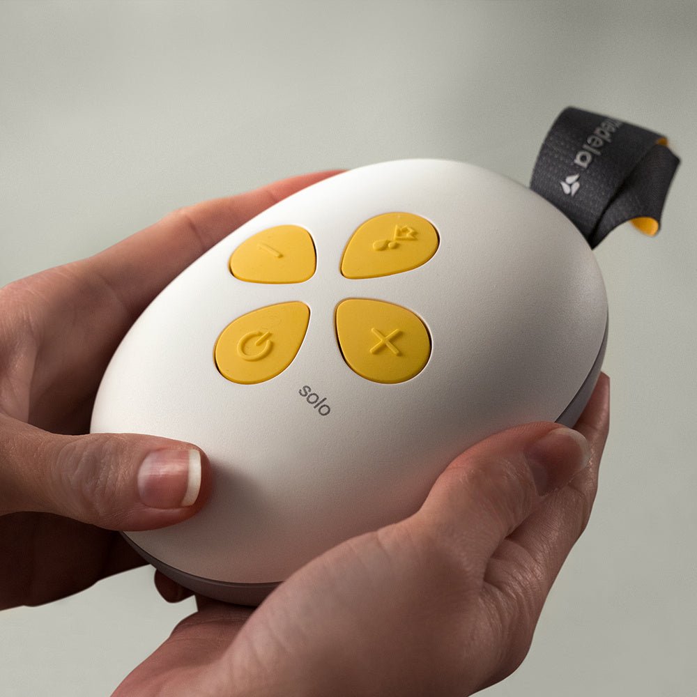 Round control pod with yellow buttons and dark wrist strap, white housing
