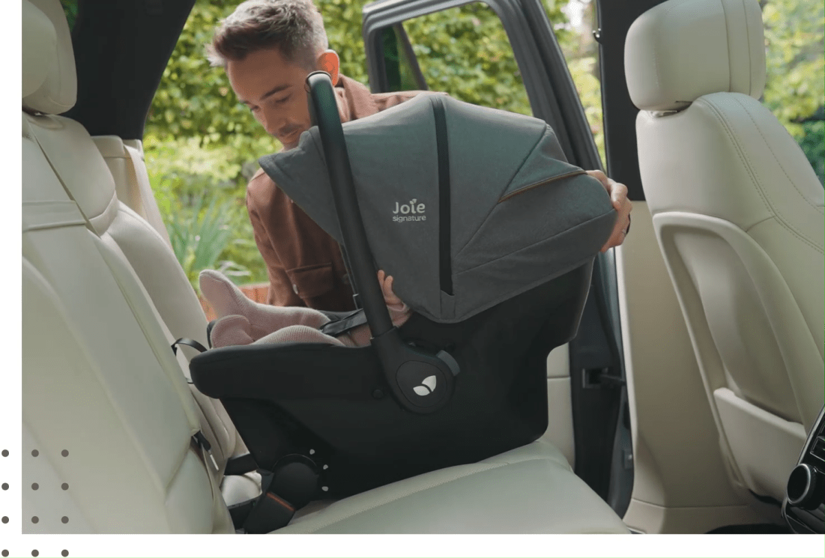 ISOFIX car seat installed in car, gray seat with canopy and harness