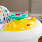 Close-up of yellow activity tray and teal spinner on white activity walker seat