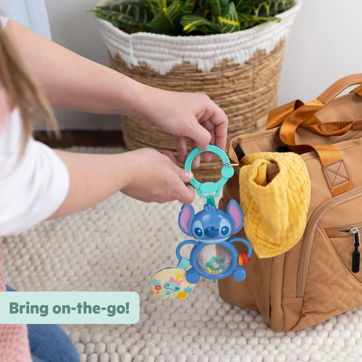 Stitch tummy tumble activity toy attached to stroller bag with teal ring and blue character