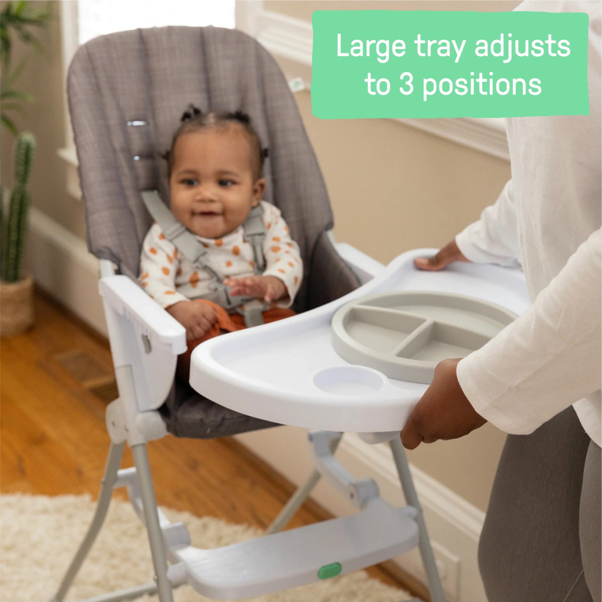 Gray high chair with adjustable tray in three-position support.