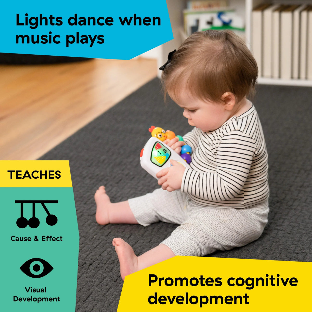 Baby holding handheld musical toy with colorful buttons and character face