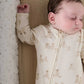 Cream teddy-print all-in-one romper with zip front and snap details at cuffs