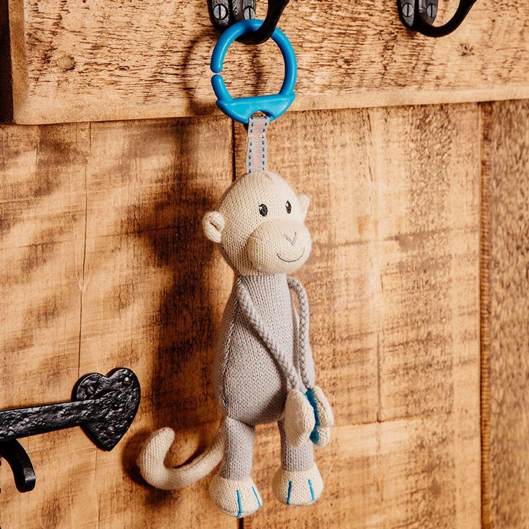 Plush teething monkey hanging from blue ring with small blue teether