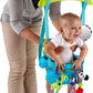 Baby wearing blue door jumper with hanging toys, zebra and green bird