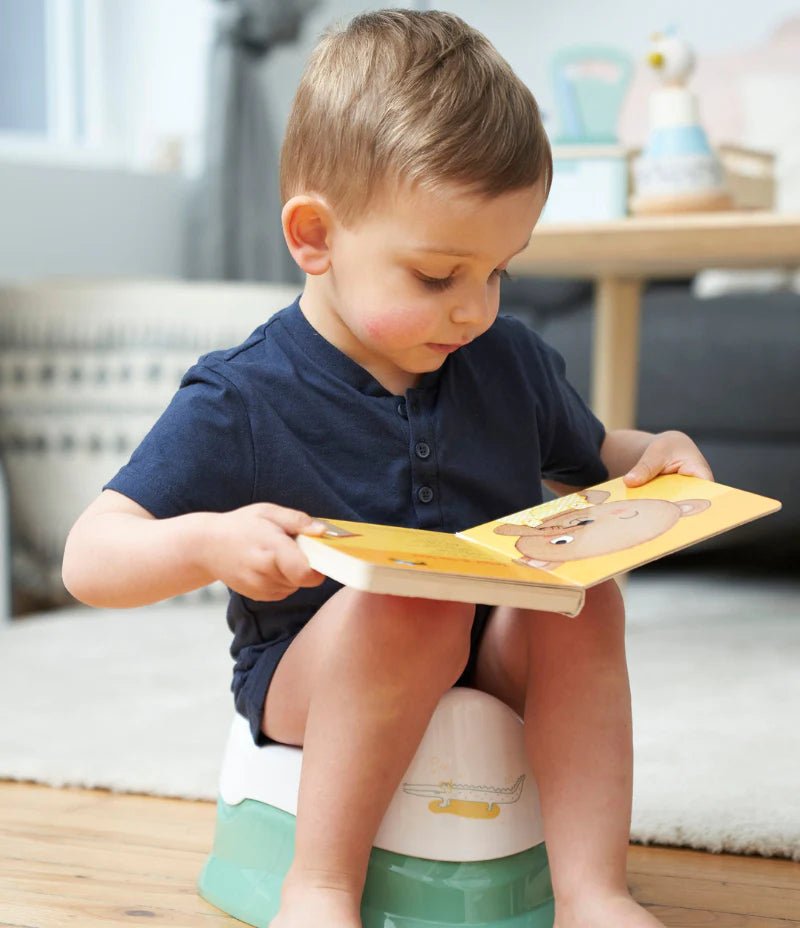 Children’s training potty with removable bowl in green and white, with child using it