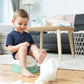 Children’s training potty with removable bowl in green and white, child kneeling beside it