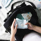 Black travel bag with open main compartment and front zipper pocket.