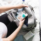 Light grey travel bag with open compartment and front zipper pocket.