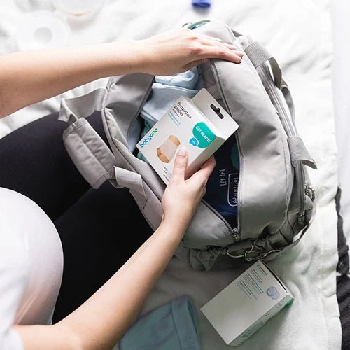 Light grey travel bag with open compartment and front zipper pocket.