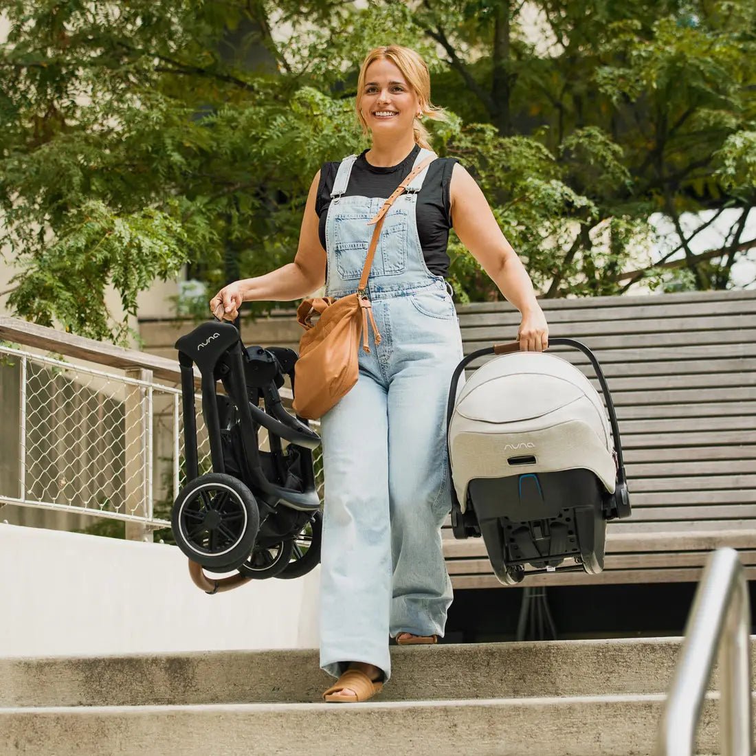 Black stroller with seat attachment and canopy, front wheels on outdoor steps