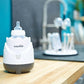 babymoov cream bottle steam warmer on a table with dark base