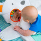 Baby on white activity mat with polar bear hood and orange ring teether