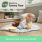 Tummy-time play mat with smiling baby lying on a white and blue padded cushion