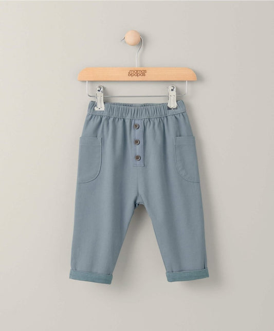 Blue twill trousers with elastic waist, front buttons, and side pockets