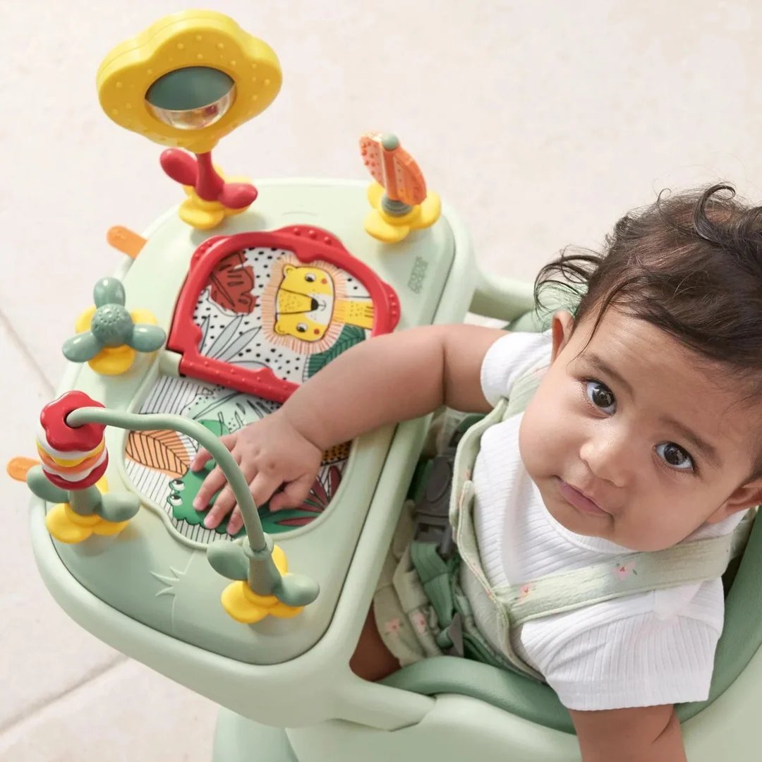 Baby play tray with animal artwork, side toys, and a child leaning in
