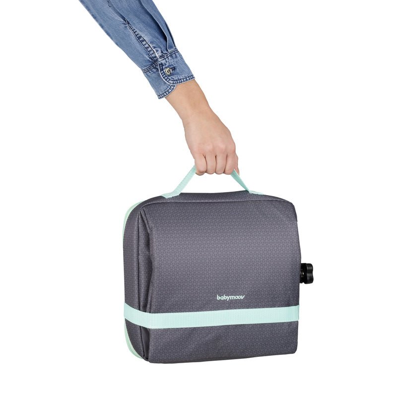 Grey booster seat held up by hand, with mint trim and side release buckle