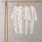 Baby sleepsuit set of 3: floral white, solid white, pale pink speckled all-in-ones