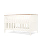 White cotbed front view with vertical slat guard rail