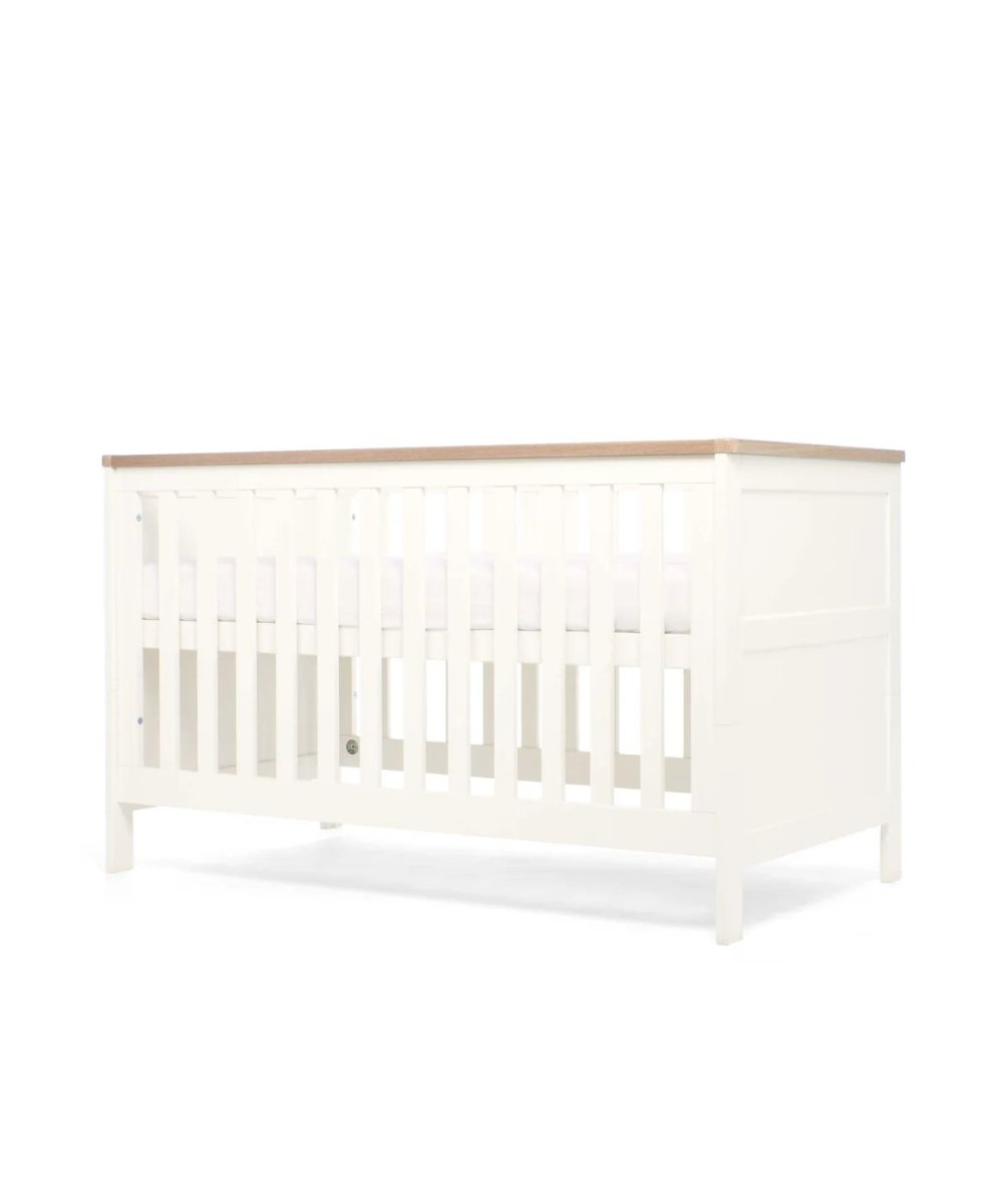 White cotbed front view with vertical slat guard rail