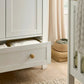 Nursery wardrobe open interior with pull-out drawer, white cabinet, natural wood knob