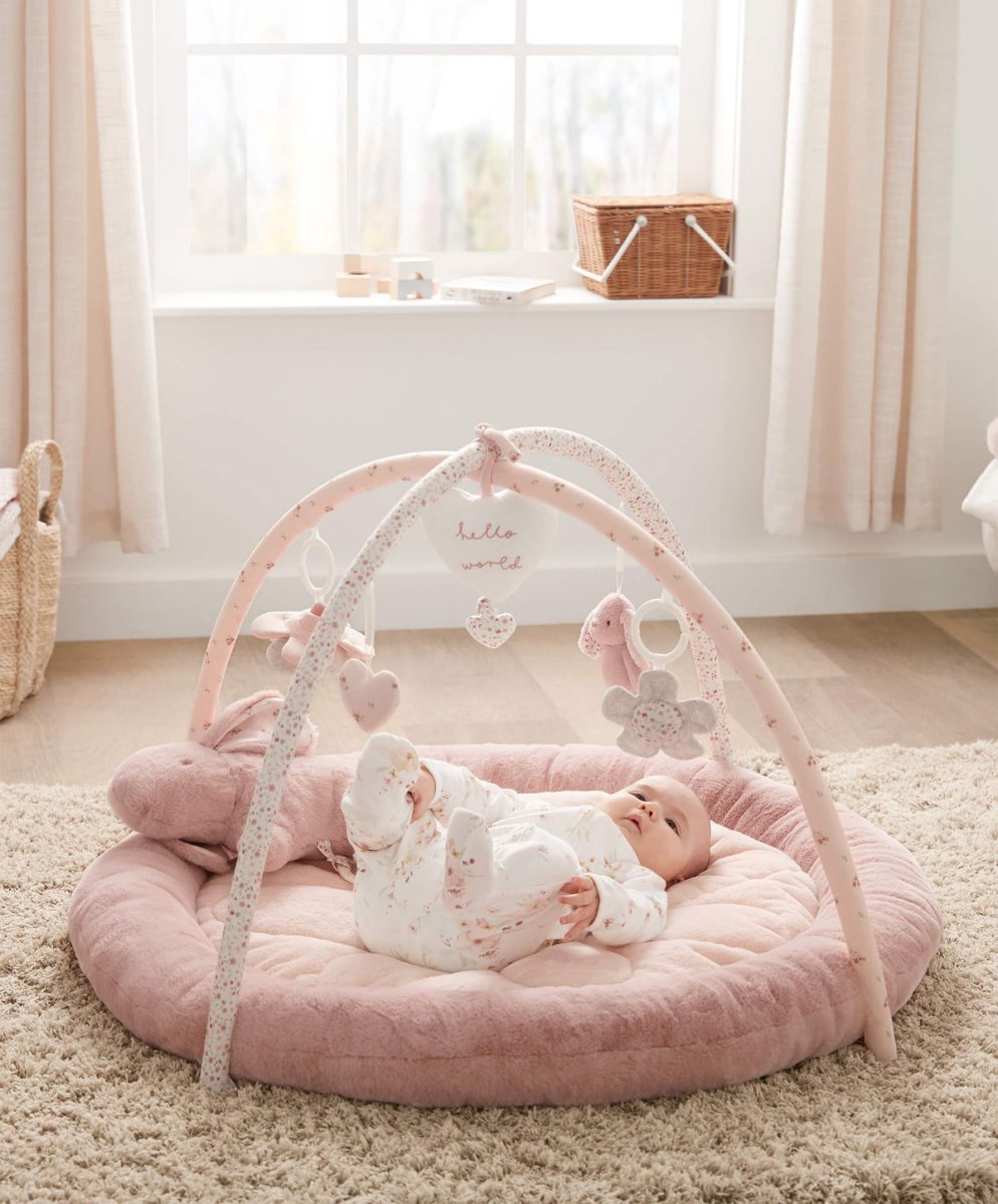 Pink bunny playmat with rounded padded base, arched frame, hanging heart and plush toys