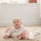 Plush bunny tummy time roll in pink; baby on top with front ring