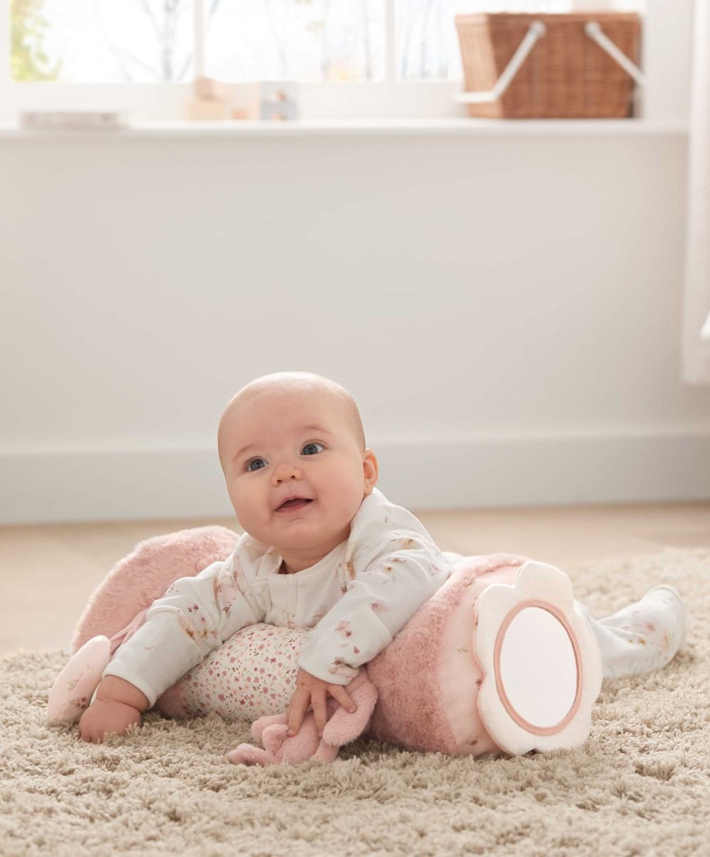 Plush bunny tummy time roll in pink; baby on top with front ring